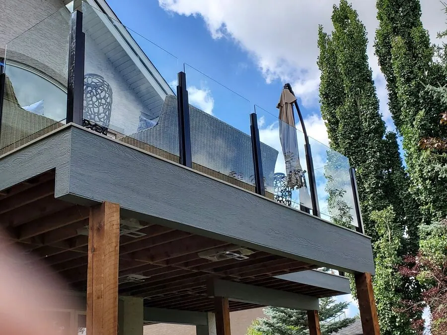 Elevated deck with glass railing, photographed so the posts and structure below are visible