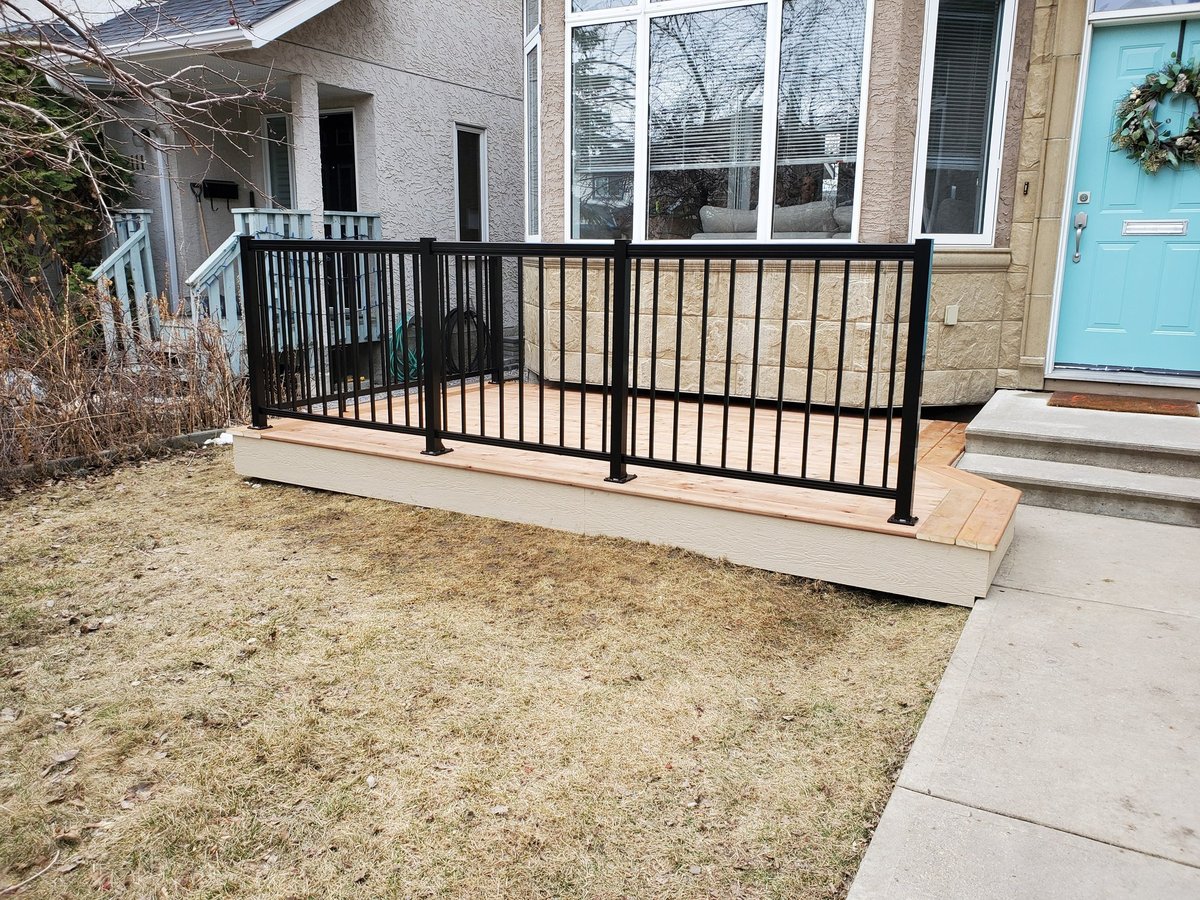Black aluminum picket railing around a low wood front deck on a WBD project